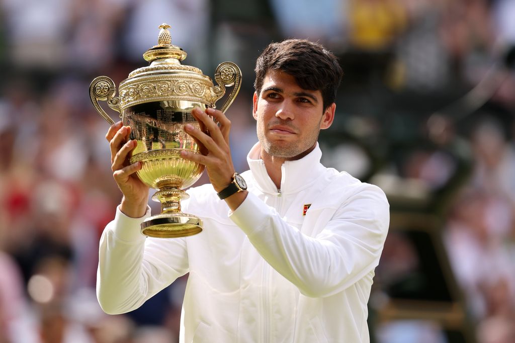 carlos alcaraz holding trophy at wimbledon in 2024