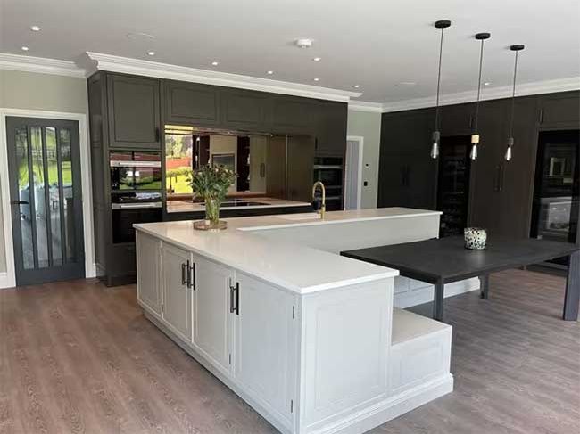 9 a large white kitchen with wooden floors