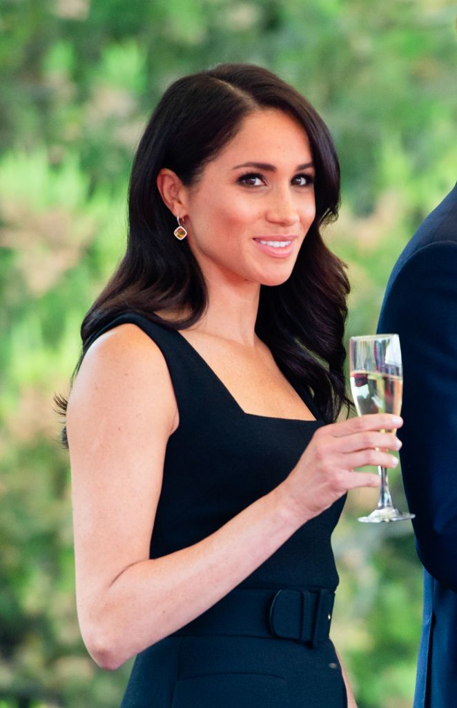 Meghan holding a glass of wine