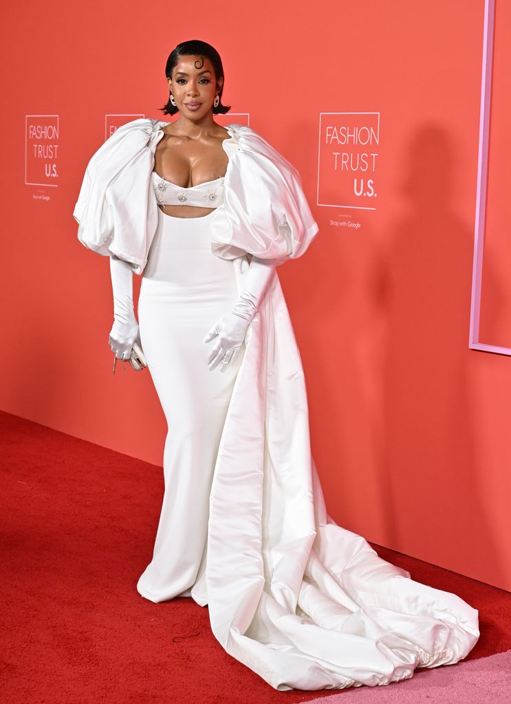 Kelly Rowland on red carpet in a caped white look