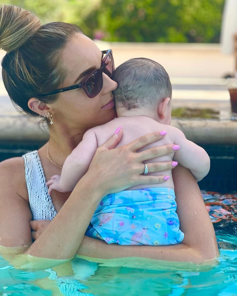 Emily andre holding baby Arabella in pool