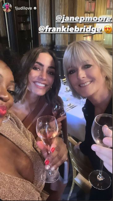 a selfie taken at a party with three women smiling and squeezing into frame each holding a wine glass and wearing party makeup and dresses