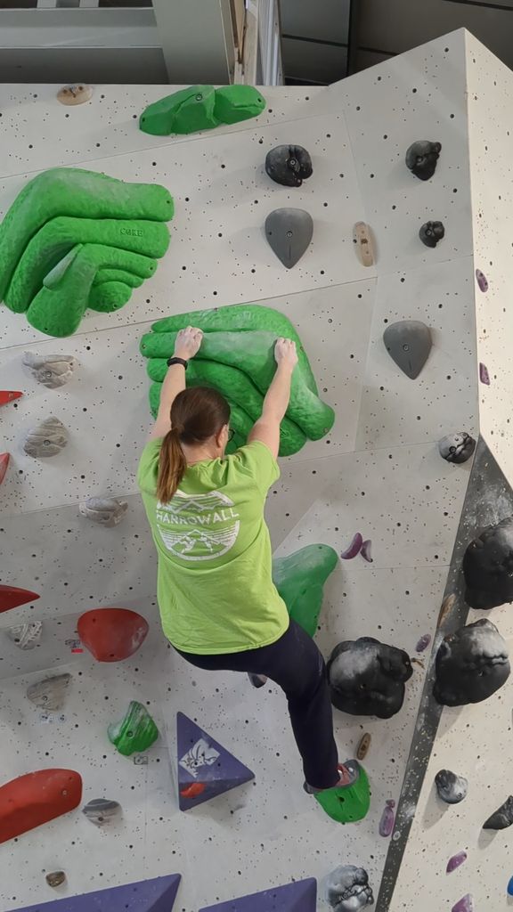 Woman in a green top on a climbing wall