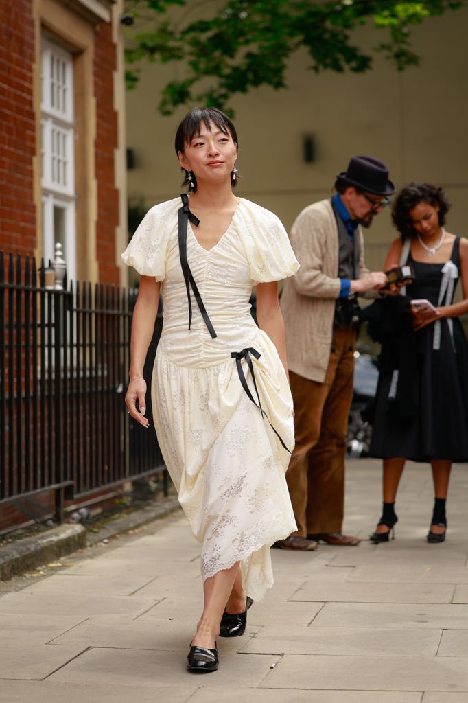 Patricia Zhou wearing black bow detailed white dress outside Yuhan Wang during London Fashion Week on September 20, 2025 in London, England.  (Photo by Hanna Lassen/Getty Images)