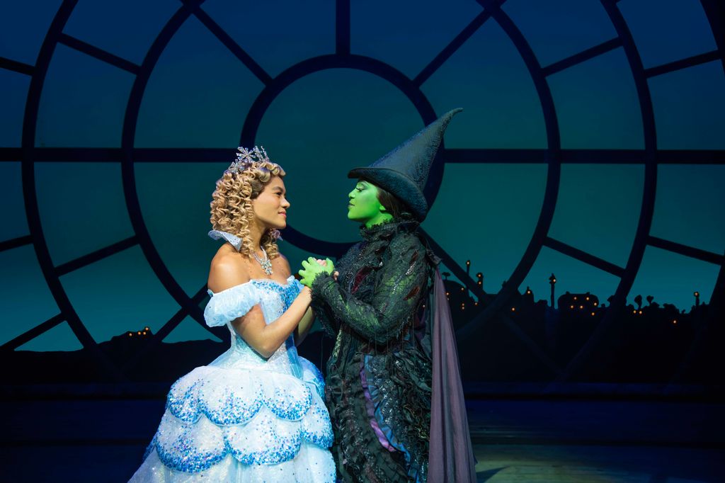 Elphaba and Glinda from musical Wicked holding hands