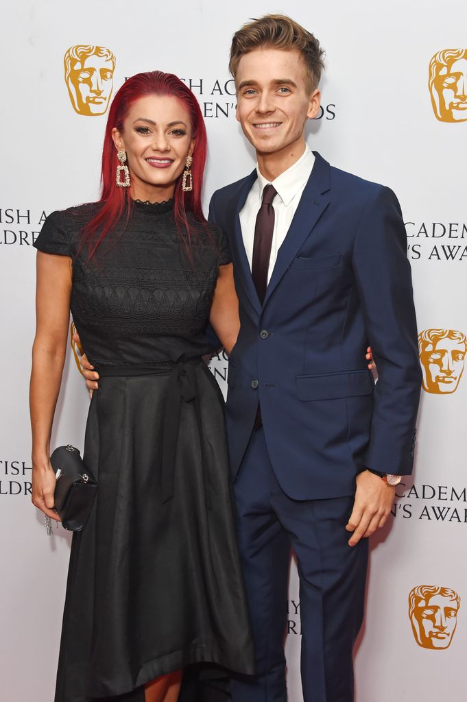 Dianne Buswell in a black dress and Joe Sugg in a blue suit