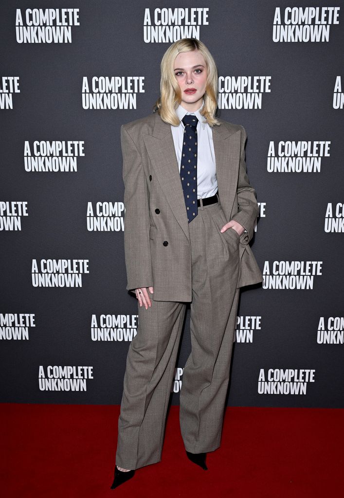 Elle Fanning in greige suit and blue tie