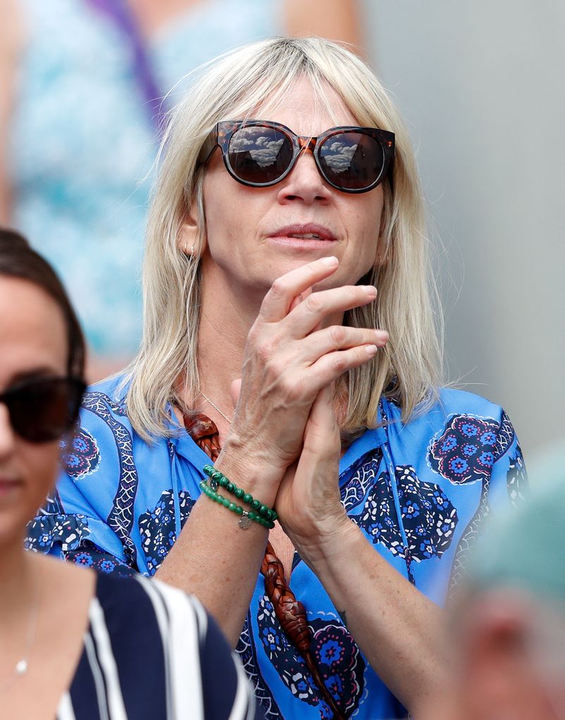 Zoe Ball clasping her hands together wearing a blue top