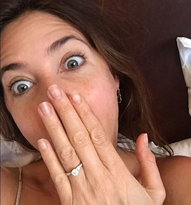 Lisa Snowdon holds her hand to her mouth and shows off her engagement ring