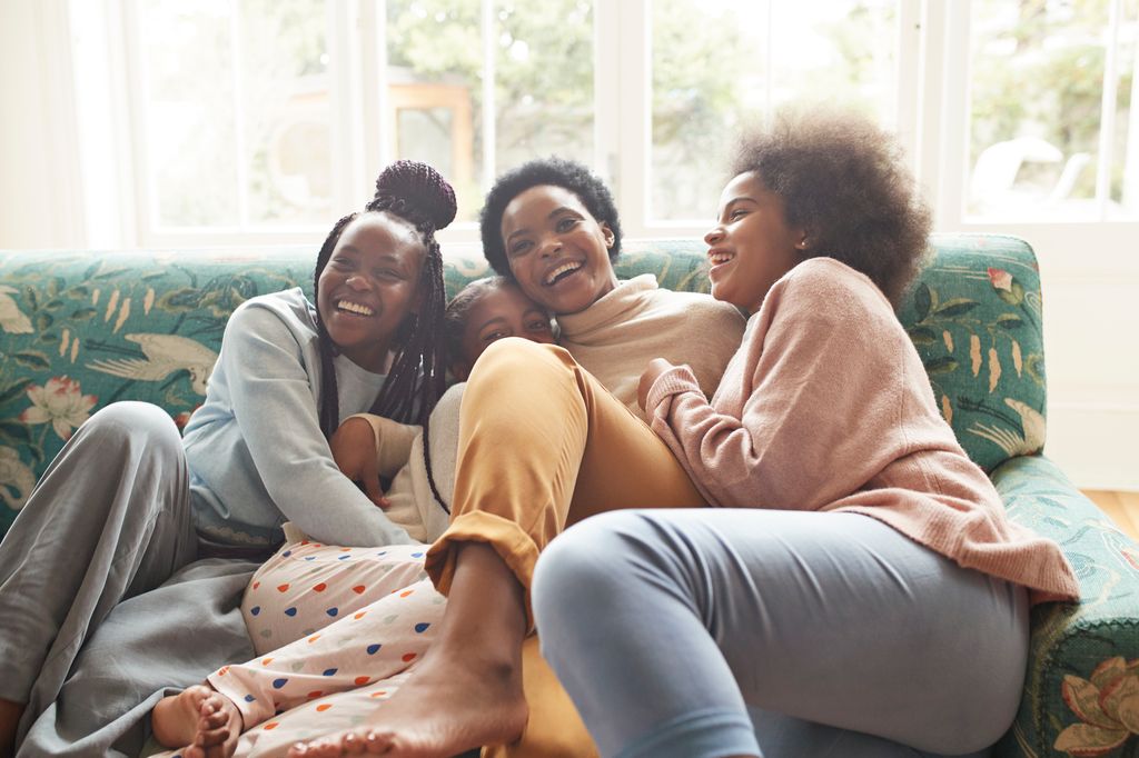 three girls hugging mum on sofa