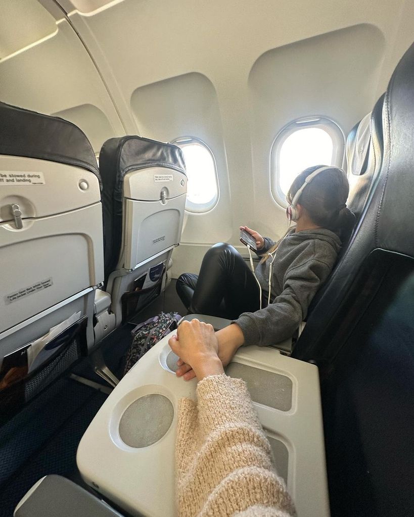 Nadiya Bychkova holding hands with daughter Mila on a plane