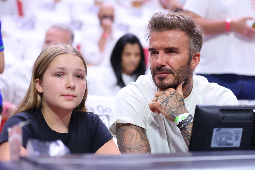 Harper and David Beckham looking serious at a football game