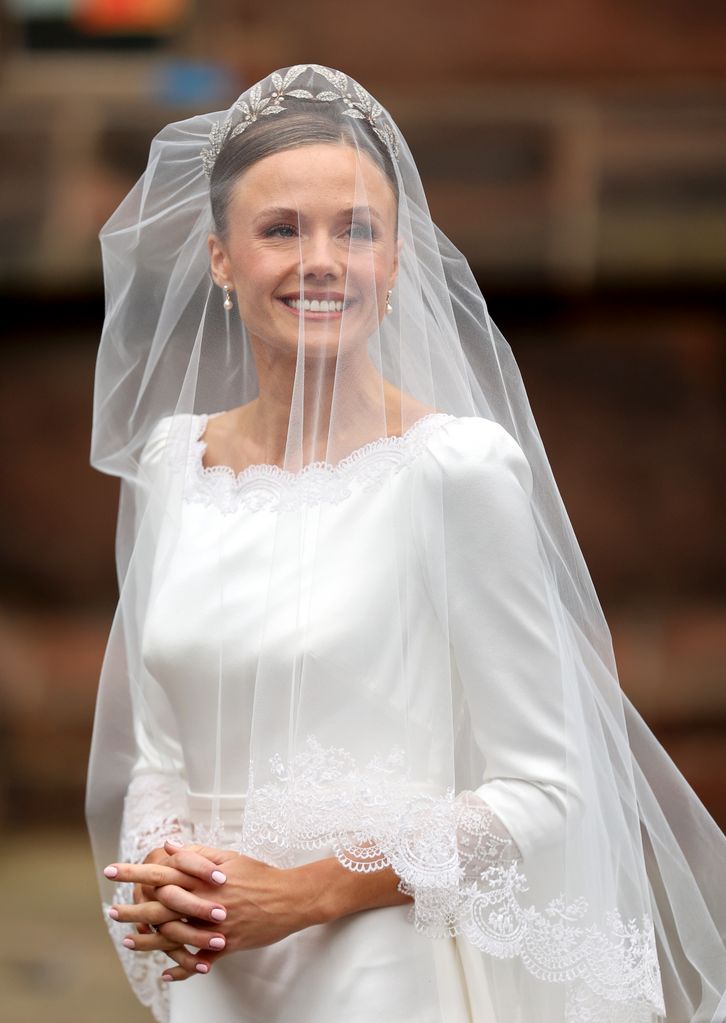 Olivia Henson is spellbinding in backless wedding dress and flyaway ...