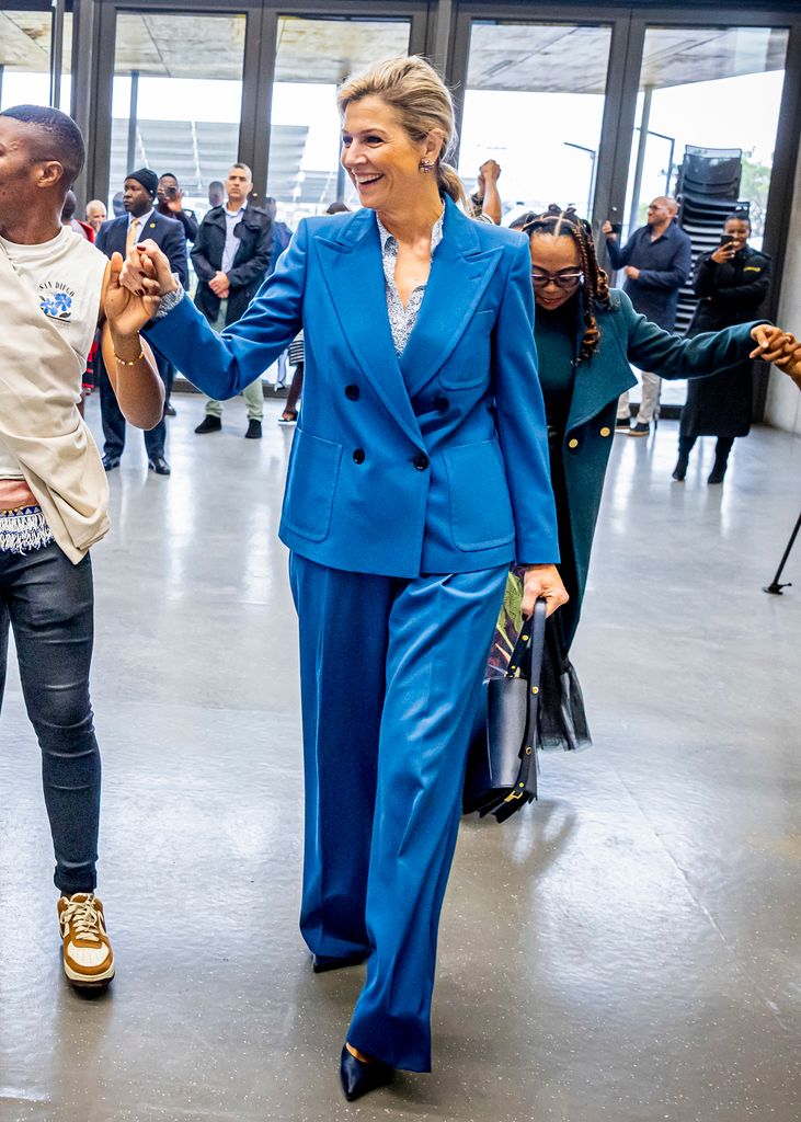 La Sra. Maxima de los Países Bajos en Sudáfrica es un traje de color azul