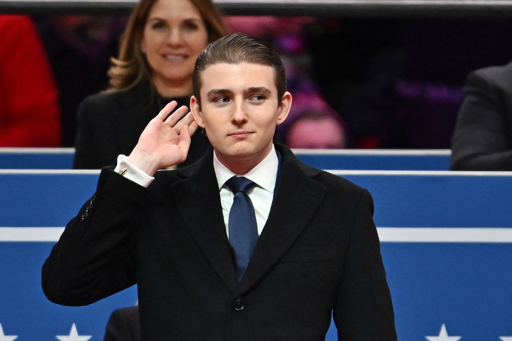Barron Trump gestures after being acknowledged by his father US President Donald Trump during the inaugural parade inside Capital One Arena, in Washington, DC, on January 20, 2025