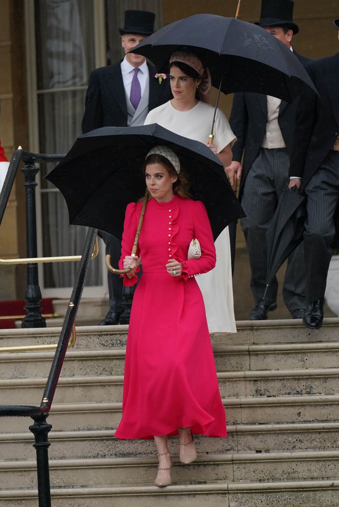 Princesa Beatrice em um vestido rosa vibrante segurando um guarda-chuva