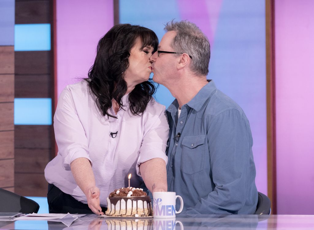 Coleen Nolan kissing Michael Jones while holding a cake