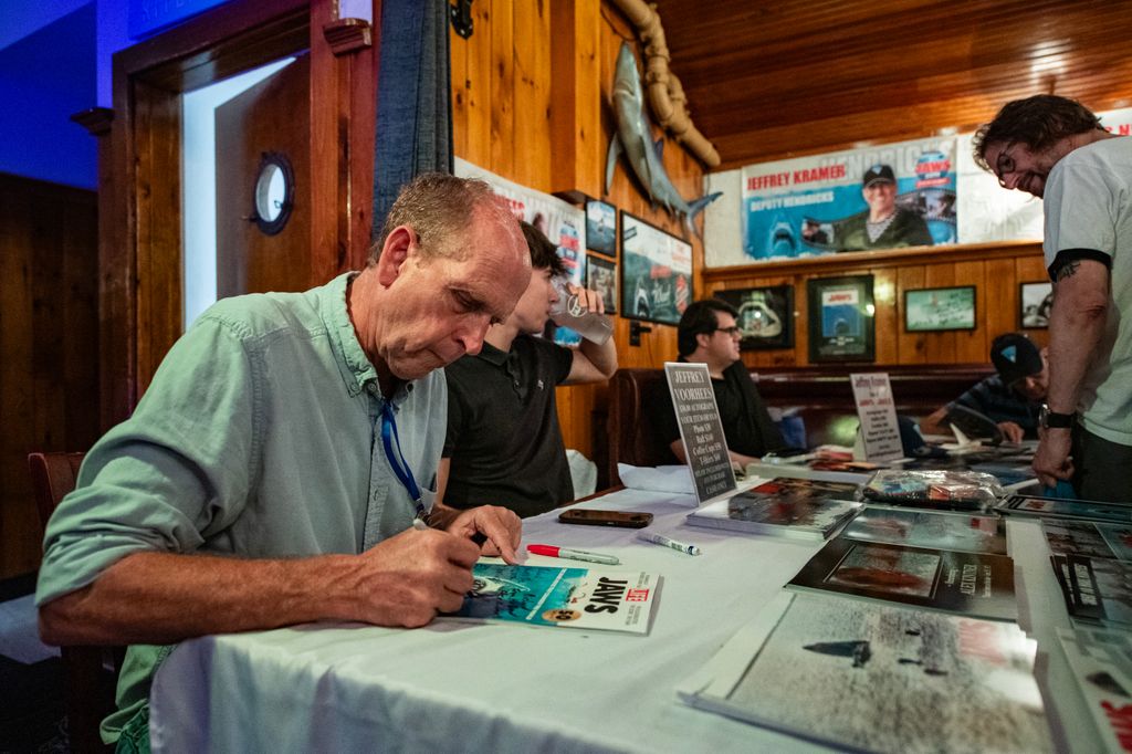 Jeffrey Voorhees in blue shirt signs autographs for fans during the Jaws 50th Anniversary celebration      