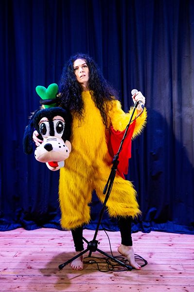 Jordan Gray in yellow fur costume carrying a Goofy head