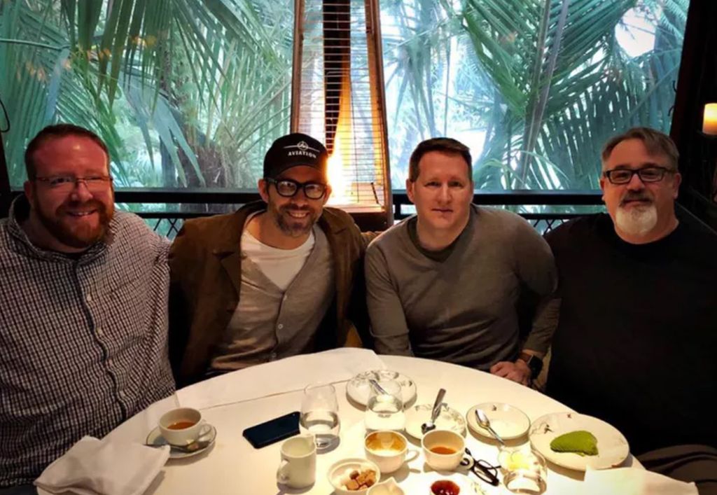 Ryan Reynolds sating at a round table with his three brothers