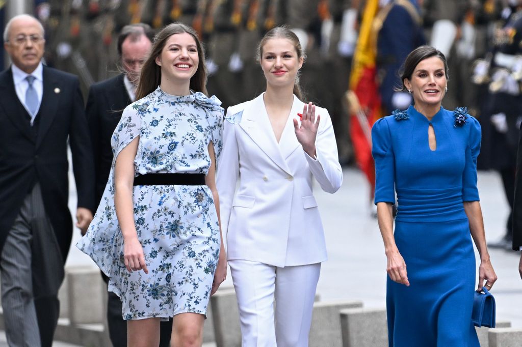 Infanta Sofia walking with a waving Princess Leonor and Queen Letizia