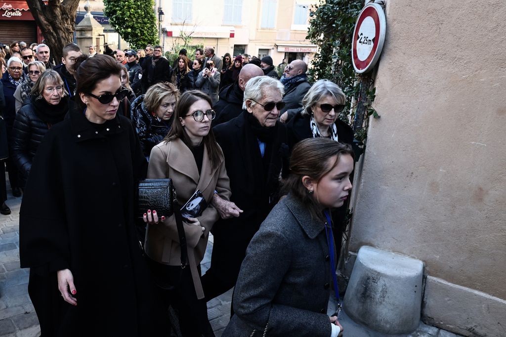 Brigitte's husband, Bernard, was joined by hundreds of mourners as they walked behind her hearst at her funeral