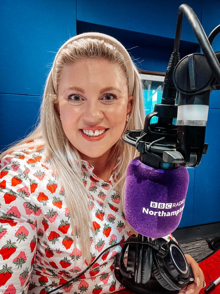 woman in a strawberry print dress recording a radio show