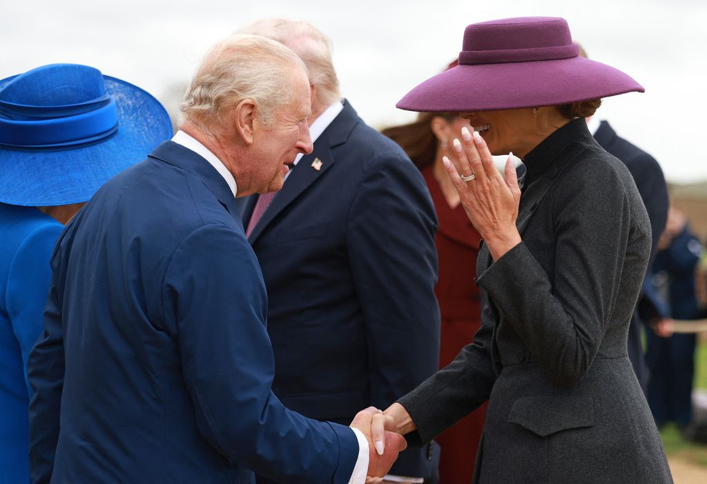 Britain's King Charles III shakes hands with US First Lady Melania Trump as he and Britain's Queen Camilla greet US President Donald Trump and the First Lady, upon their arrival in the grounds of Windsor Castl