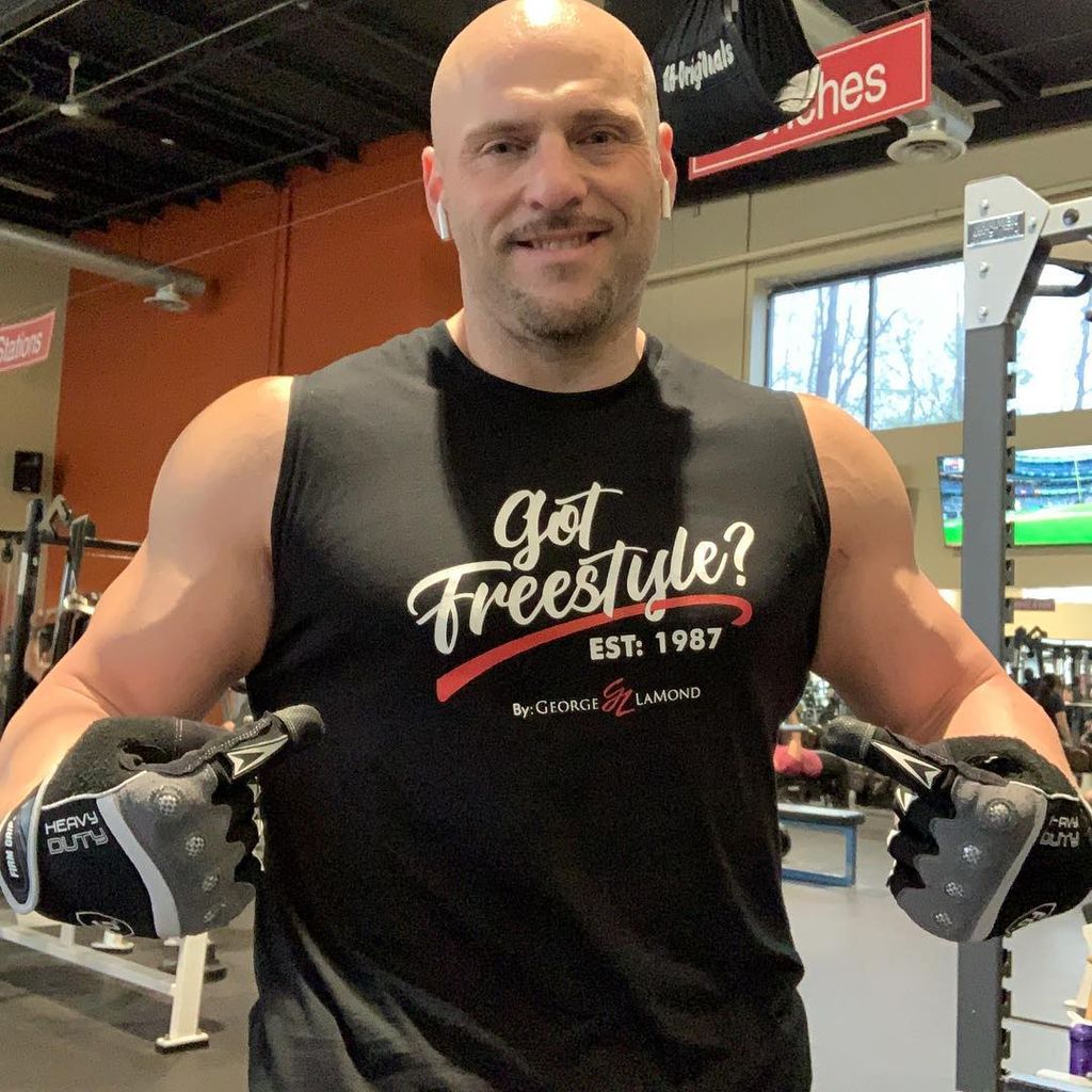 Victor Popovic points to his tank top at the gym for a photo shared on Instagram