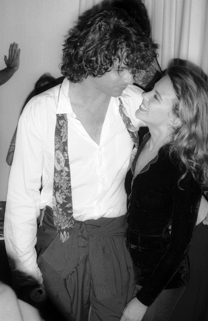 A black-and-white photo of Michael Hutchence embracing Kylie Minogue at a party