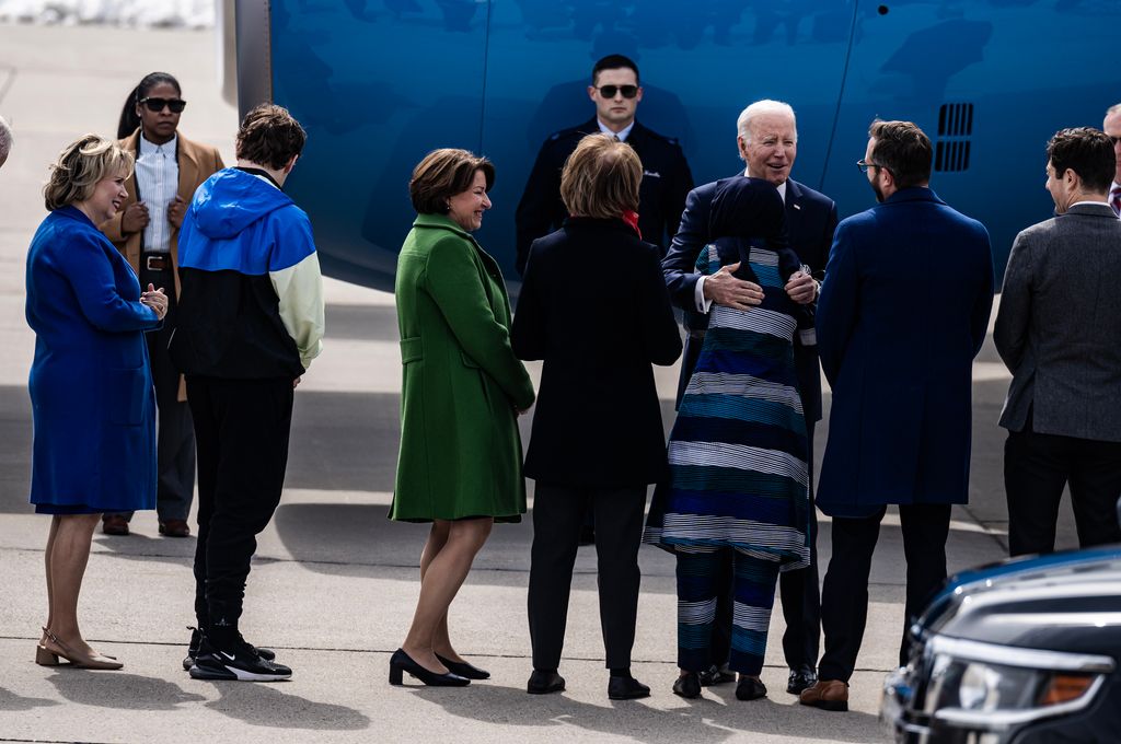 President Joe Biden gives a hug to United States Representative Ilhan Omar (third right) and greets the Minnesota delegation including Gwen Walz (left) wife of Minnesota Governor Tim Walz, their son Gus (second left)