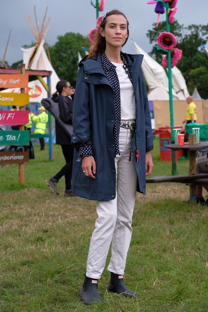 Alexa Chung attends day two of Glastonbury on June 24, 2017 in white jeans, a polkadot blouse and Hunter boots
