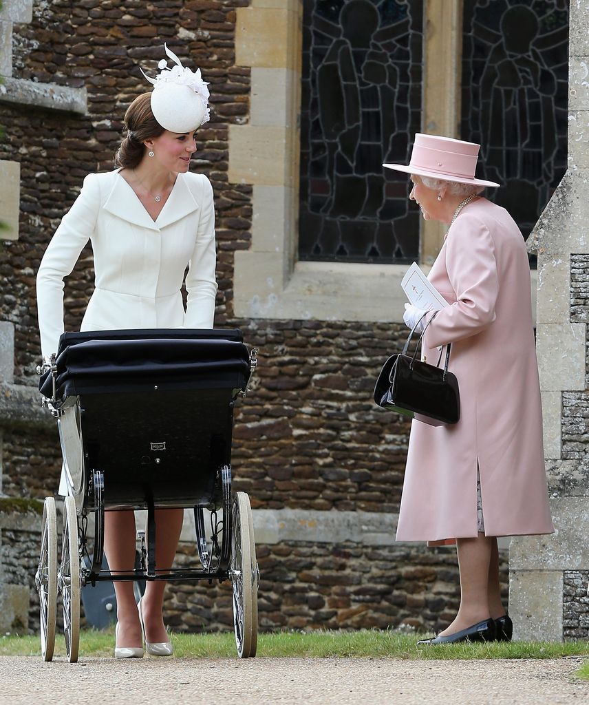 Catherine, Duchess of Cambridge pushes Princess Charlotte of Cambridge in her pram as Queen Elizabeth II looks on