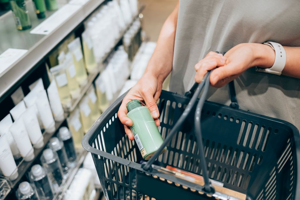 An anonymous female customer holding her basket while shopping