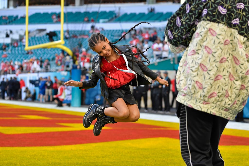 Jay-Z photographs his daughter Blue Ivy Carter as she jumps in the end zone before the start of Super Bowl LIV at Hard Rock Stadium in Miami Gardens, Fla., on Sunday, Feb. 2, 2020