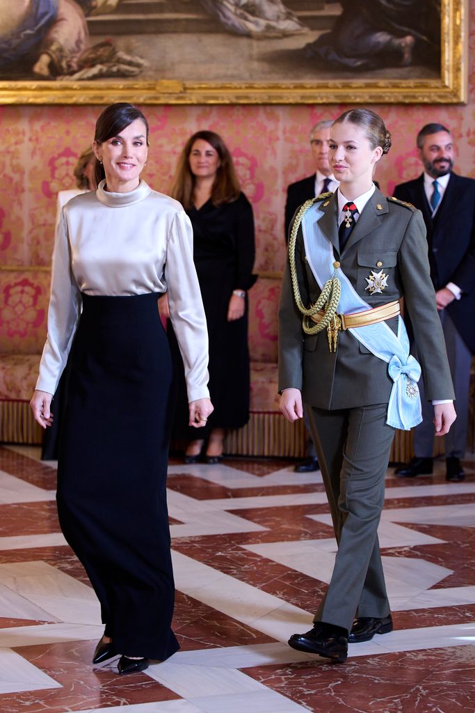 Queen Letizia in satin top and black trousers next to leonor in military uniform