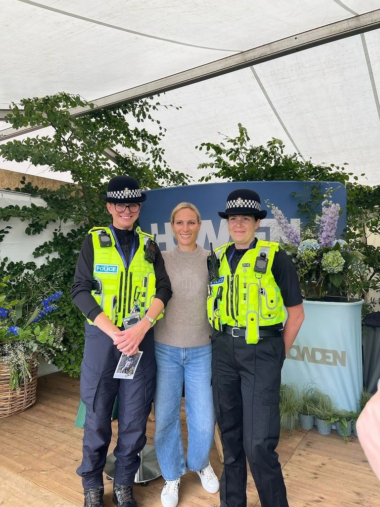Zara in jeans in between two police officers