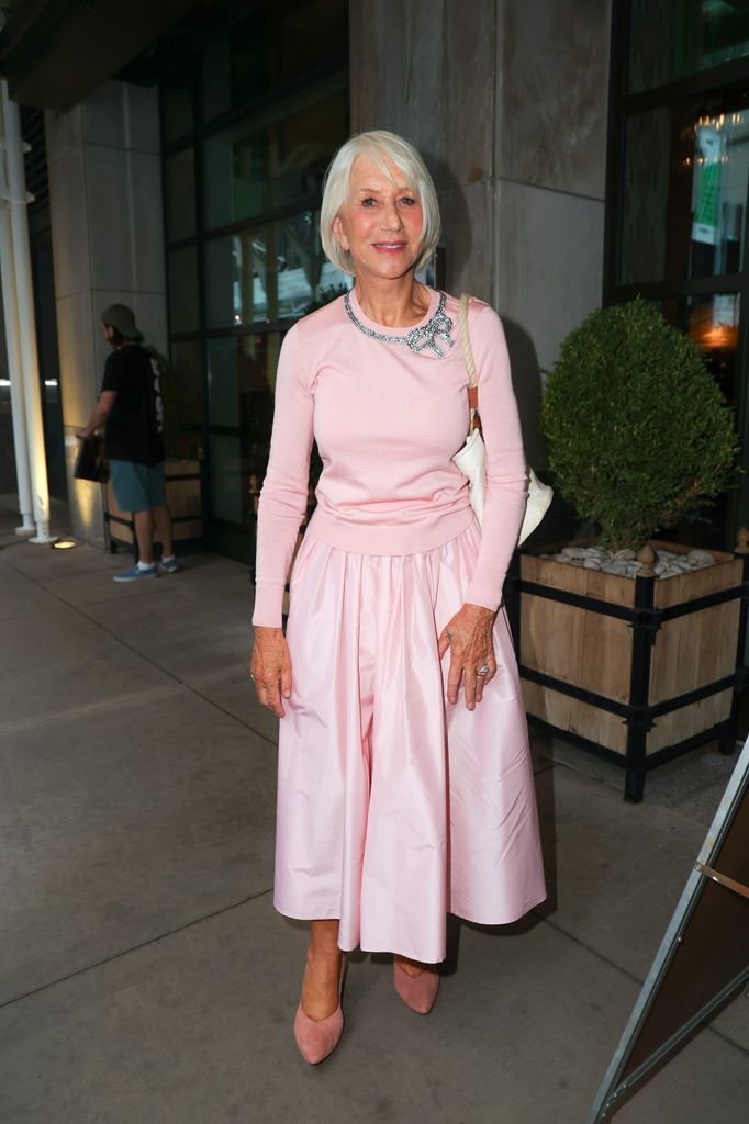 Helen Mirren on street in light pink sweater and skirt