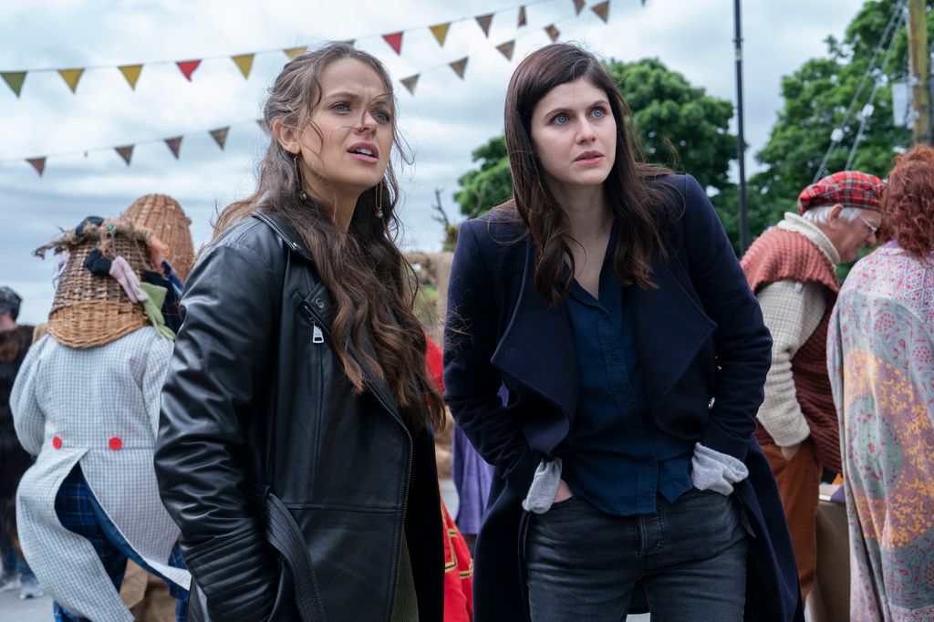 two women standing in busy street