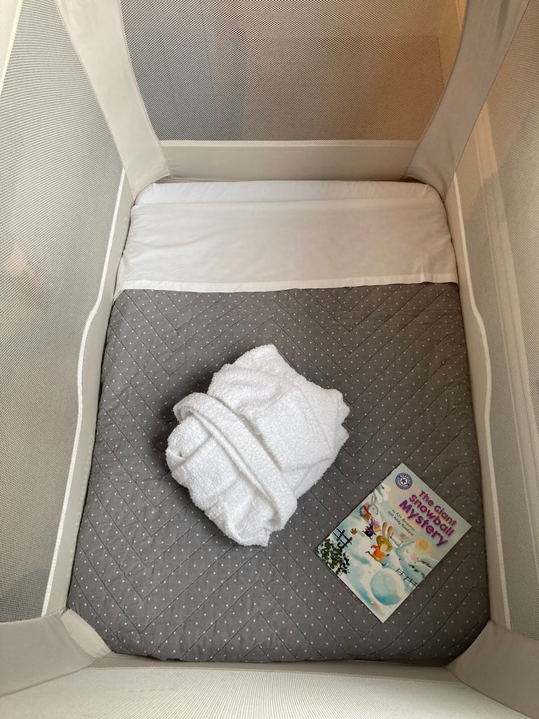 Aerial shot of a cot with a folded bath robe and book