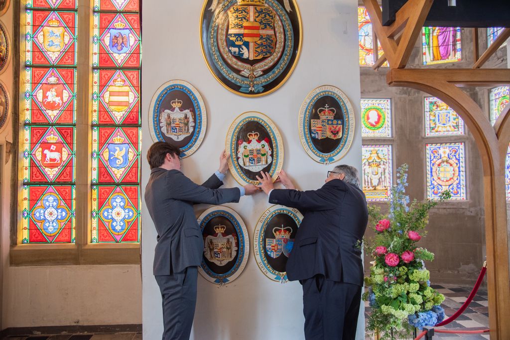 Prince Christian helps to put coat of arms on the wall