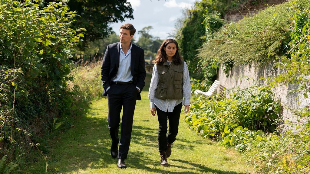 man and woman waling down green garden path