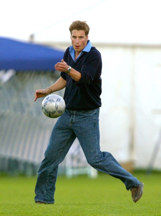 Young Prince William playing football in jeans
