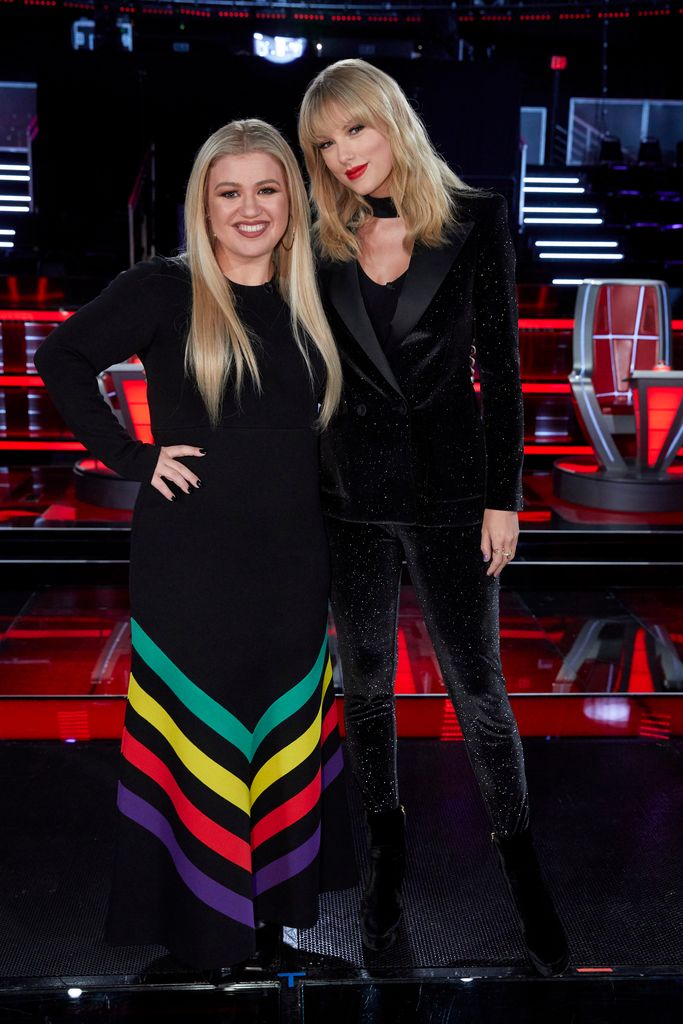 Taylor Swift and Kelly Clarkson pose. They are both wearing black