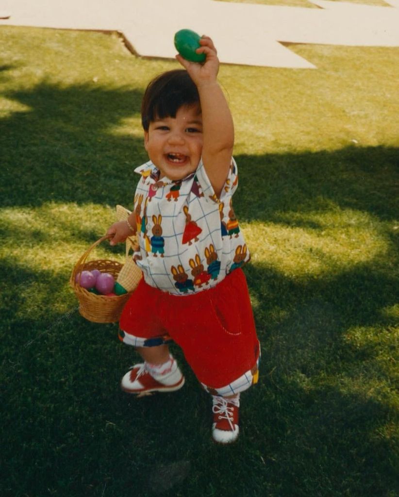 Baby Rob triumphantly holds an Easter egg