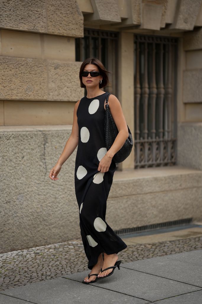 Sophia Geiss is seen wearing a black and white long sleeveless polka dot knit dress with round neckline from Zara; a