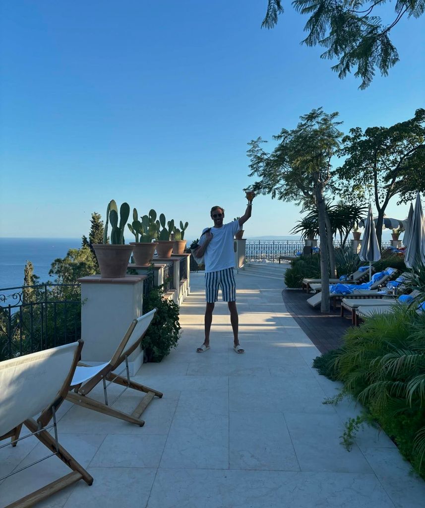 Peter Crouch in shorts waving from balcony in Sicily 