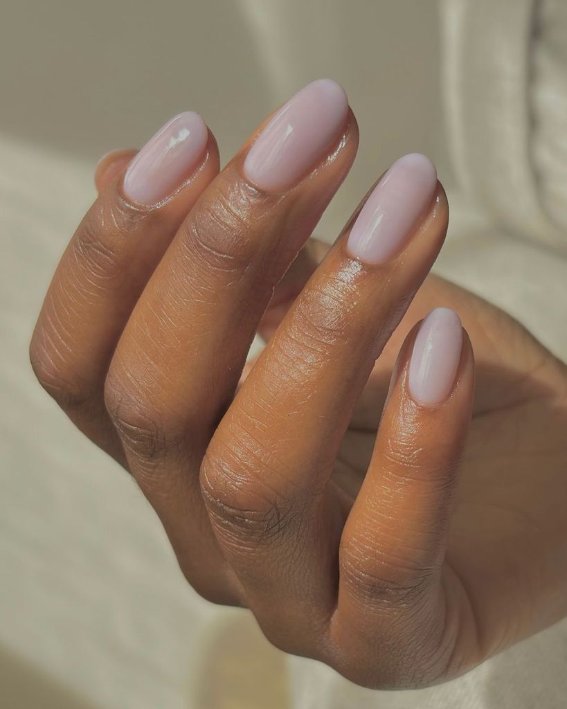 Lavender Milk Nails: Short, rounded nails with a natural-looking sheer lavender polish, offering a clean and subtle style that enhances the natural beauty of the nails with a polished glow.