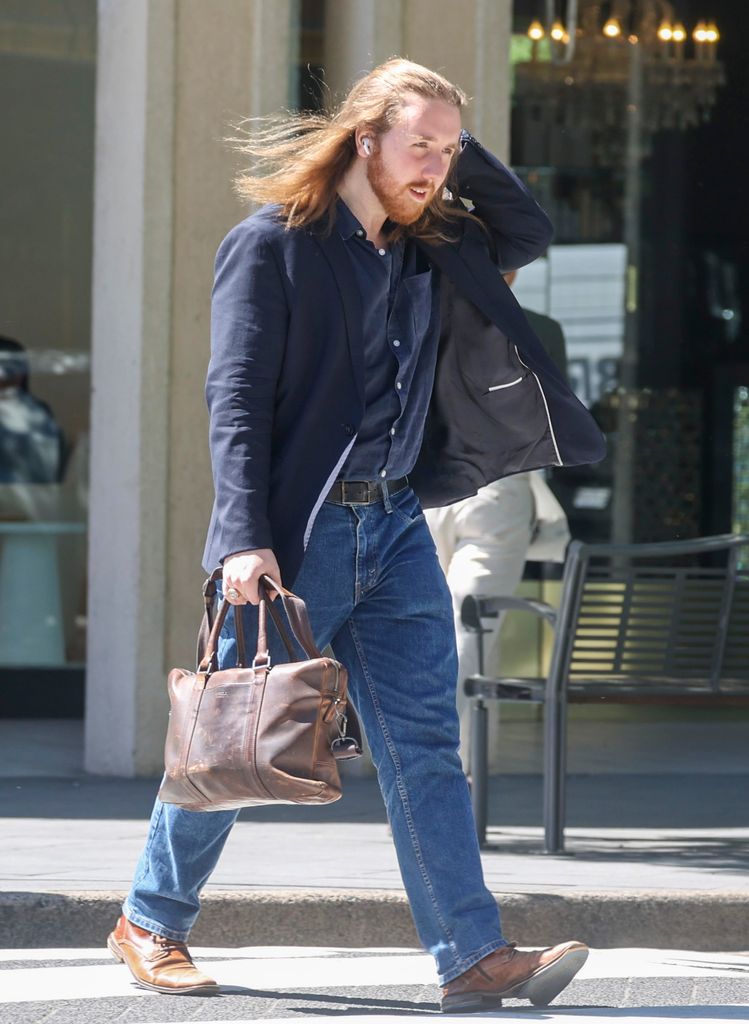 Charles Spencer Crow in navy blazer and jeans with long hair