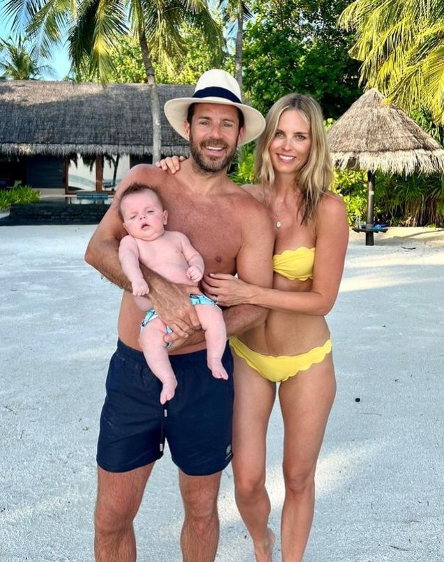 Jamie Redknapp and Frida holding a baby on the beach